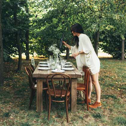 girl in park setting up an outdoor dinner table