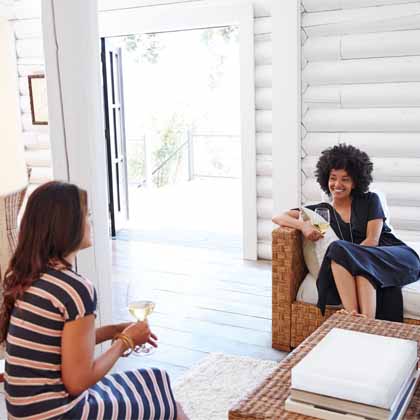 Two women sitting with wine and talking