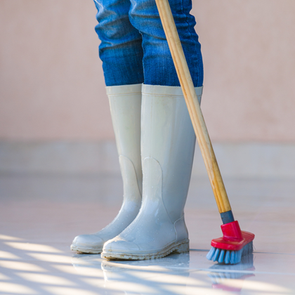 Winter tidy-up tips - girl sweeping in rubber boots
