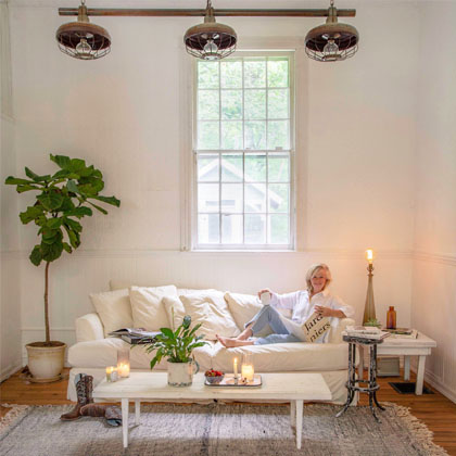 image of Wendy reading on a couch in a white, cottage style room