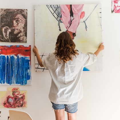 A woman hanging up paintings
