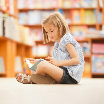 Student reading a book in a school library
