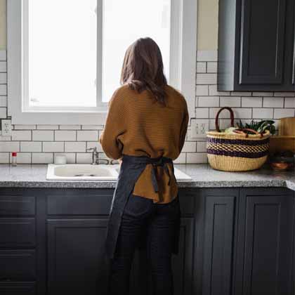 girl in black kitchen with reusable shopping bag