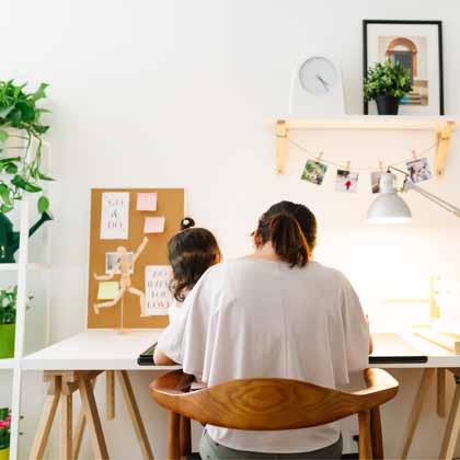 mother and daughter sitting at a desk reading