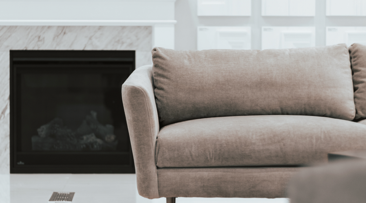 A couch next to a fireplace.