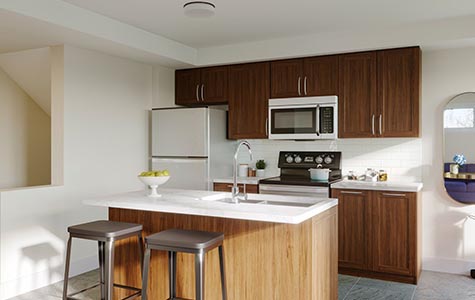 An interior shot of the Jasmine Infusion Terrace Home model shows off its brightly-lit kitchen and island.