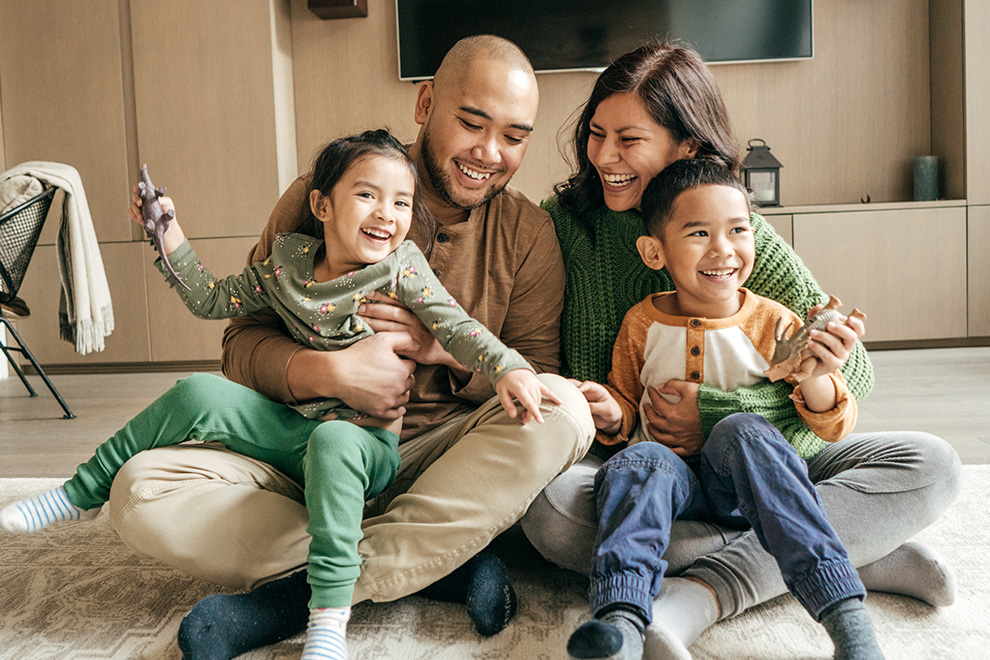 Family smiling in front of their TV