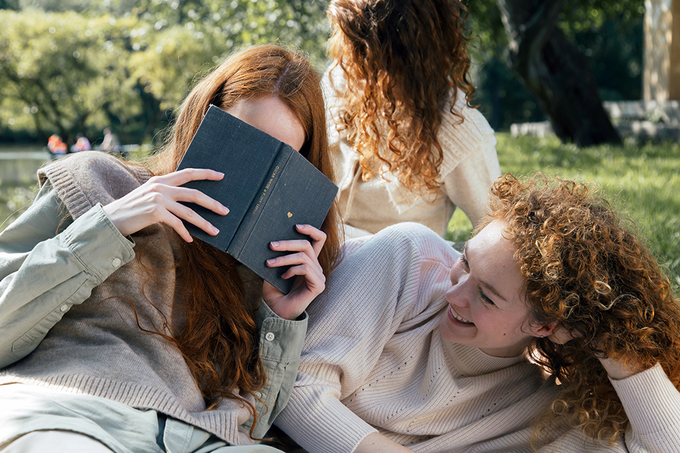 Friends reading outside and smiling