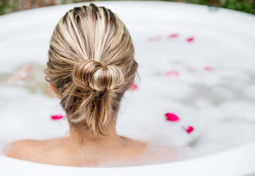 a woman sitting in a bathtub with bubbles