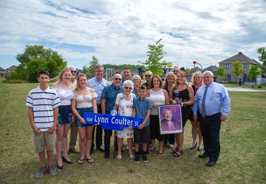 Mayor Jim Watson, local Councillor Jan Harder, retired Nepean Police Deputy Chief Devon Fermoyle, Member of Provincial Parliament Lisa MacLeod, Minto Communities’ Hugo Lalonde, nominator Darrell Bartraw with former Justice of the Peace, Lynn Coulter and her family.