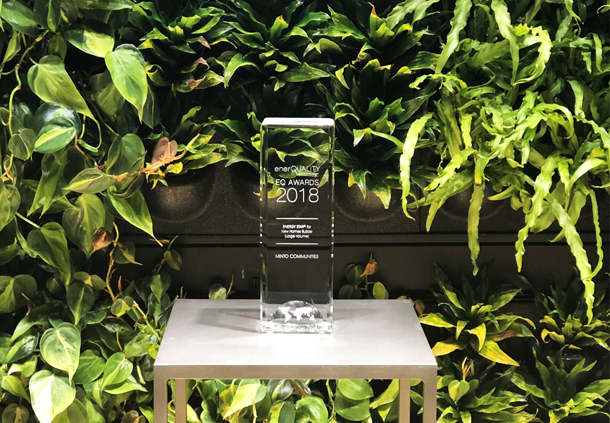 Trophy in the form of a clear rectangle sitting on a stool in front of a green background