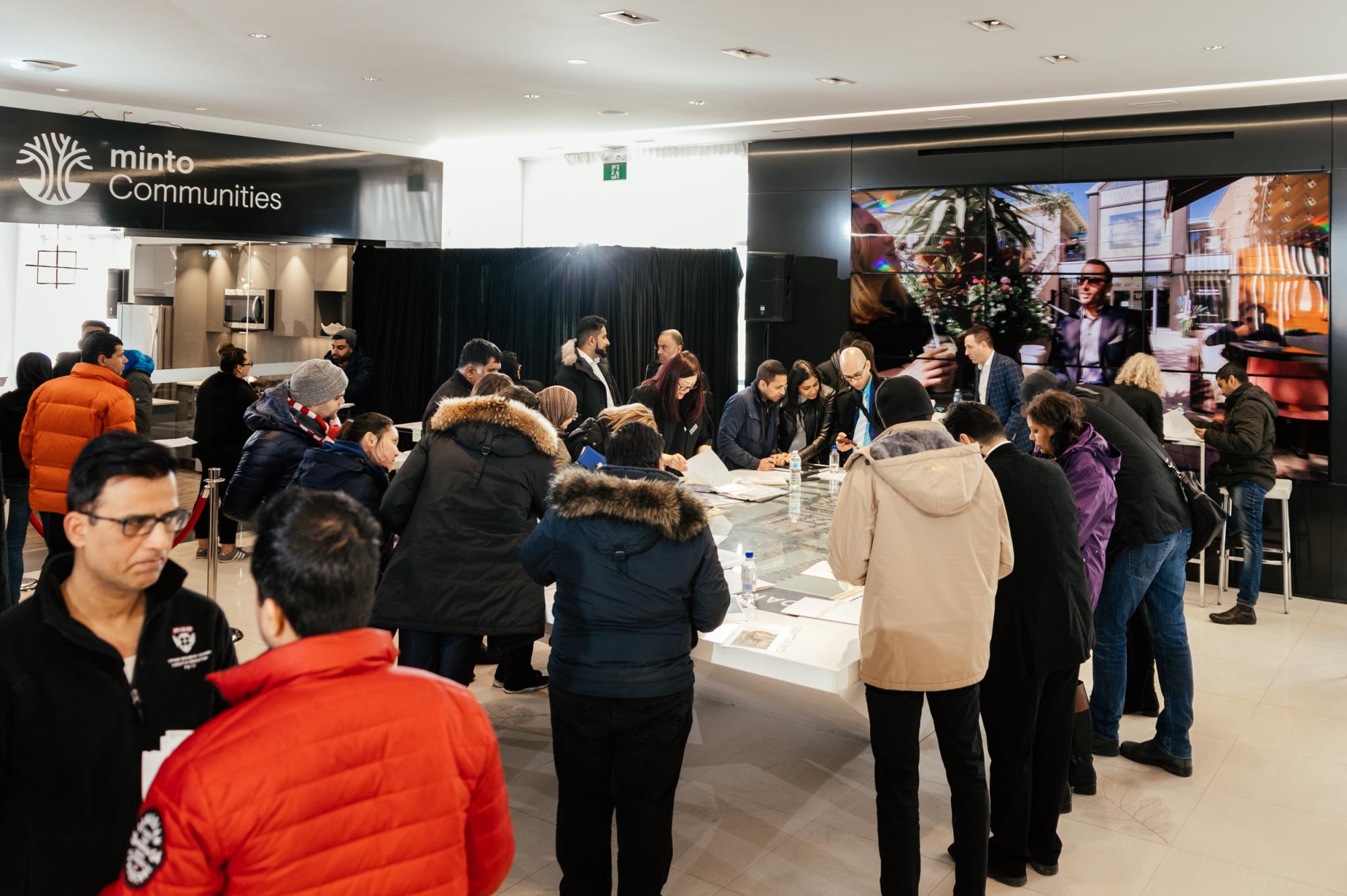 A room filled with people at a development sales center 