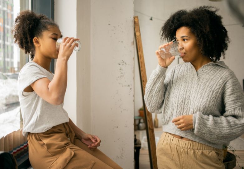Child drinking water with mom