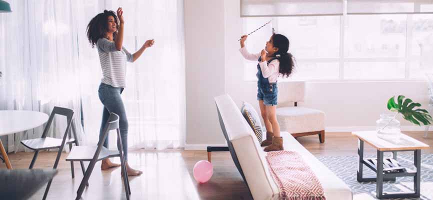 mom and daughter playing with pink balloons in the living room