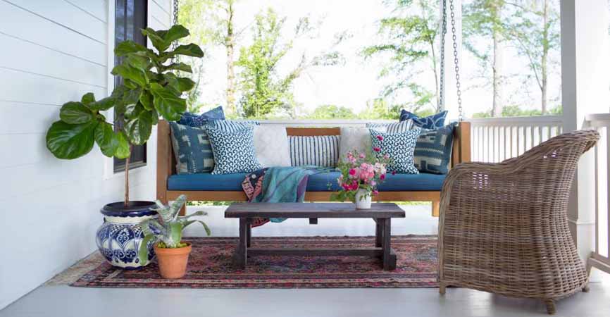 porch with plants and a hanging bench chair