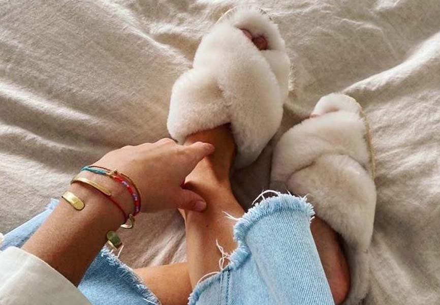 A woman sitting with fluffy slippers