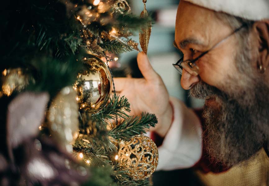Santa Claus looking at a Christmas ornament 