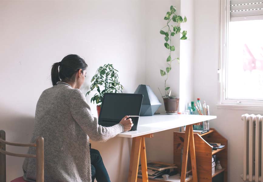 Girl sitting in front of her laptop in her kitchen