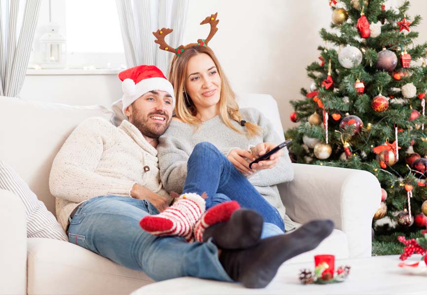 A couple sitting on the couch watching tv 