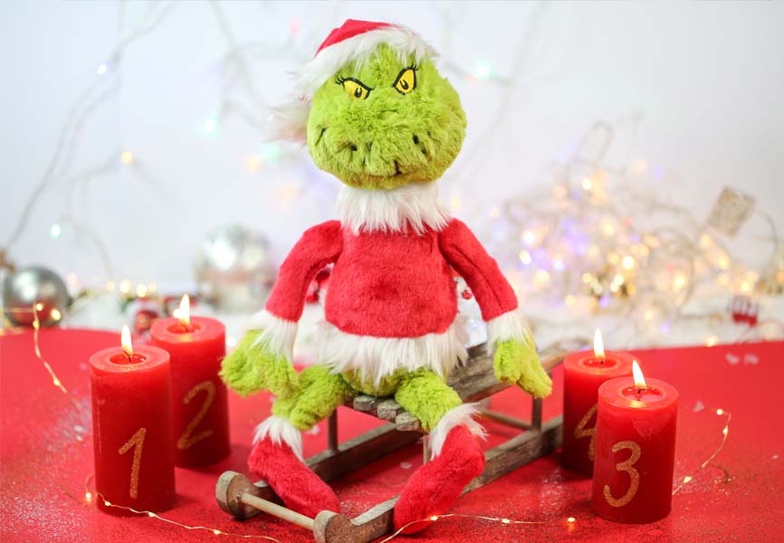Grinch doll sitting on a wooden sleigh