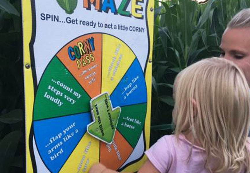 Picture of a mom and girl walking into a corn maze