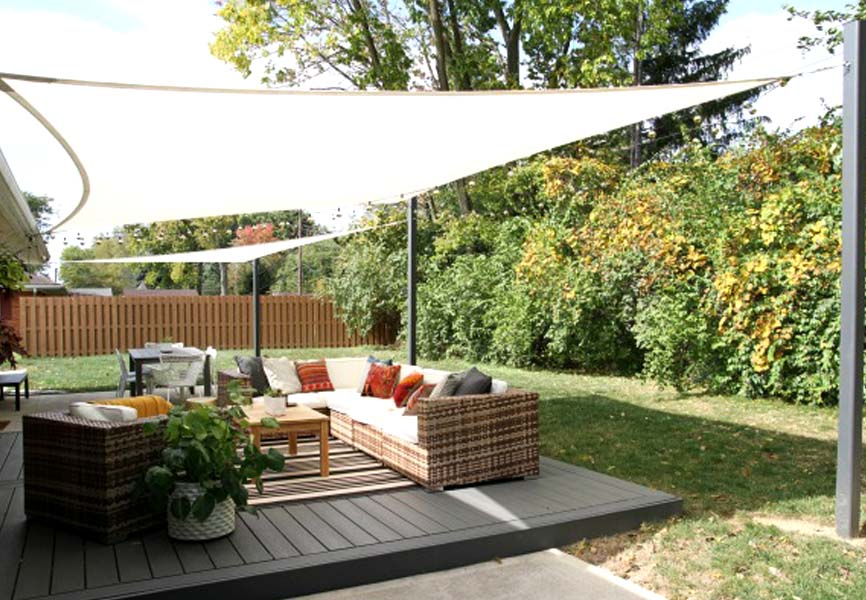 Sun shade sail covering backyard patio set