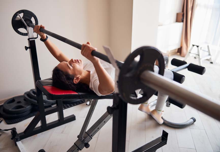 woman doing a barbell workout in a garage