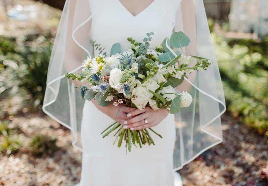 A bride standing with a bouquet 