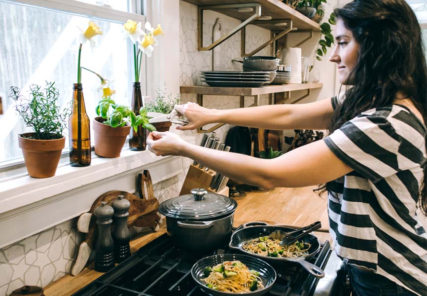 Girl cooking noodles on stove top