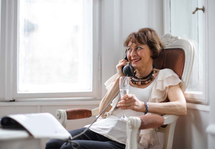 Lounge room with woman talking on phone and holding a glass of wine