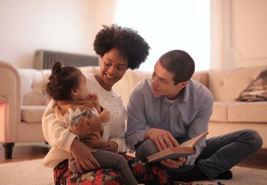 Mom and dad reading to their daughter