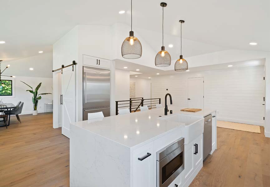 Renovated kitchen with quartz counter tops and white tiles