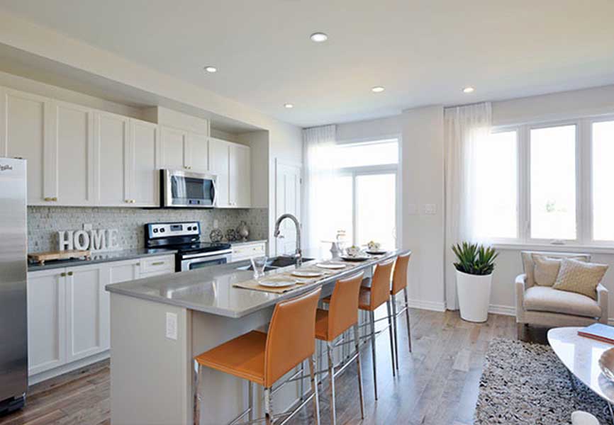 Light grey kitchen island with orange chairs