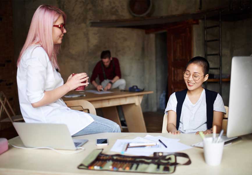 Women talking by their computers