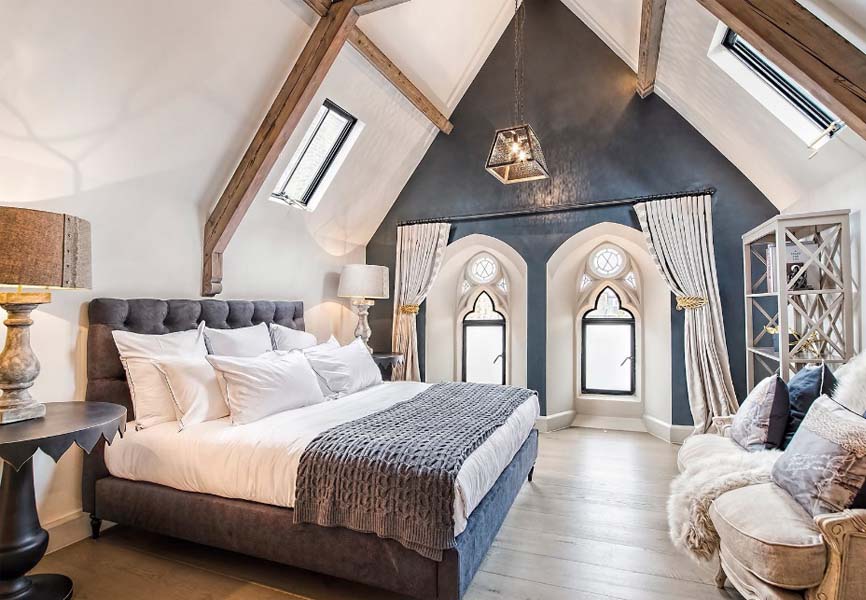 French country bedroom with high ceilings and a big white bed