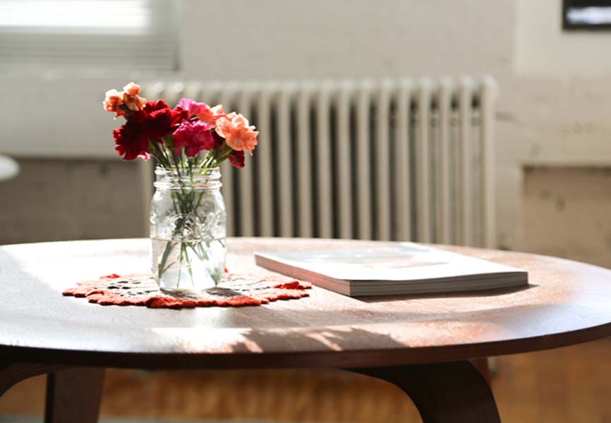 pink and orange flowers in mason jar on a coffee table