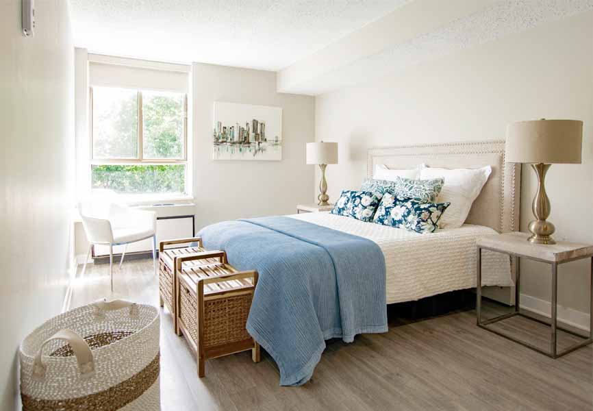spacious apartment bedroom with white and blue bedding