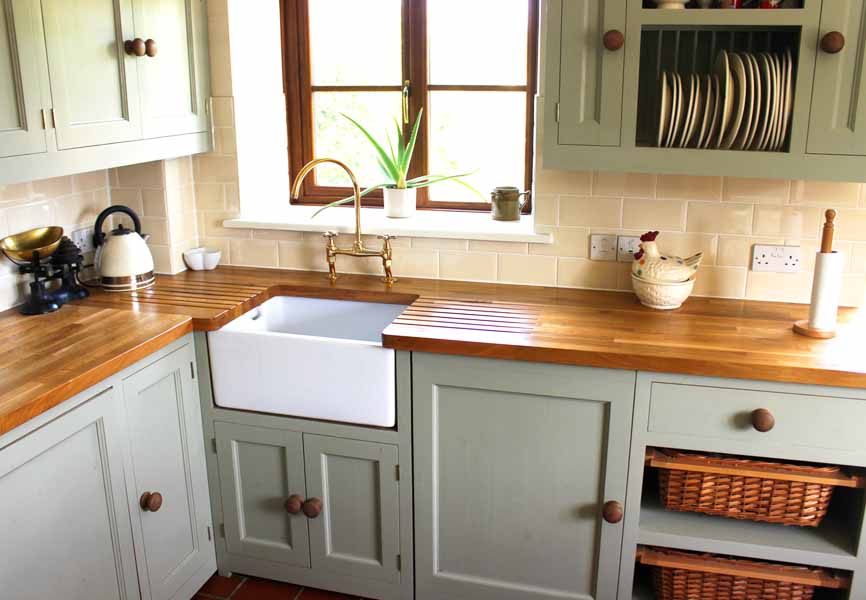 mint coloured kitchen with wood counters and plants