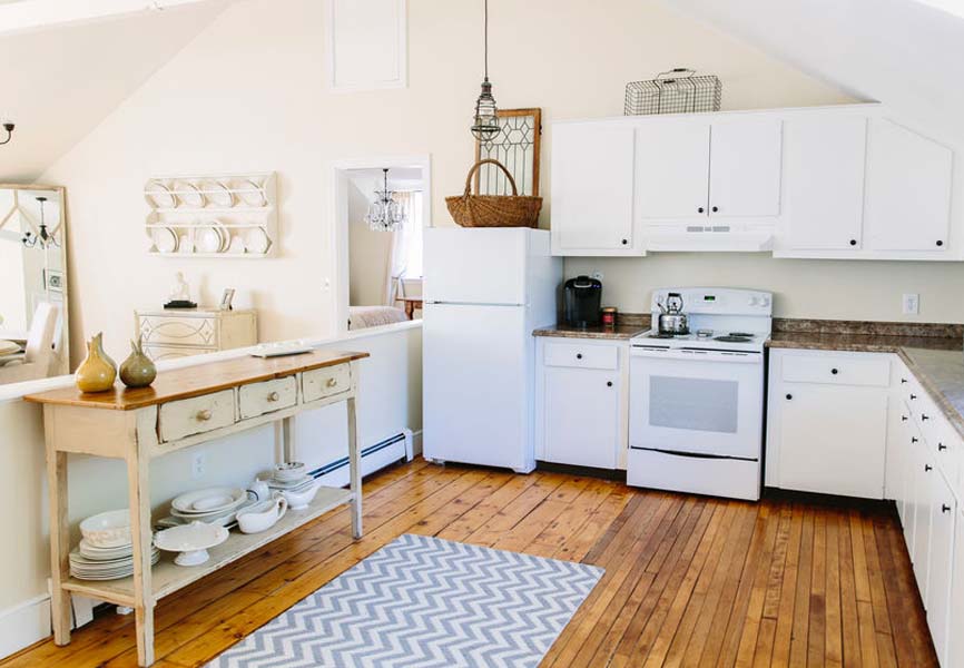 farmhouse kitchen with wood floors and white cabinetry