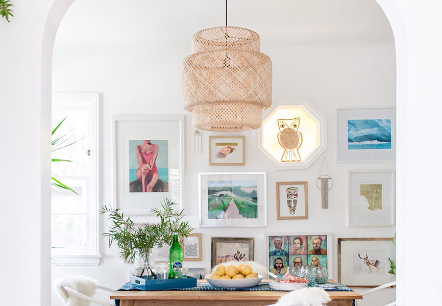 Wicker ceiling light fixture in front of gallery wall