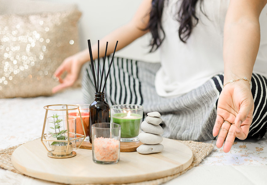 Girl sitting meditating with candles and crystals