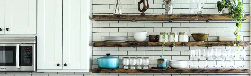 Kitchen with open shelving with organized plates, cups and bowls displayed