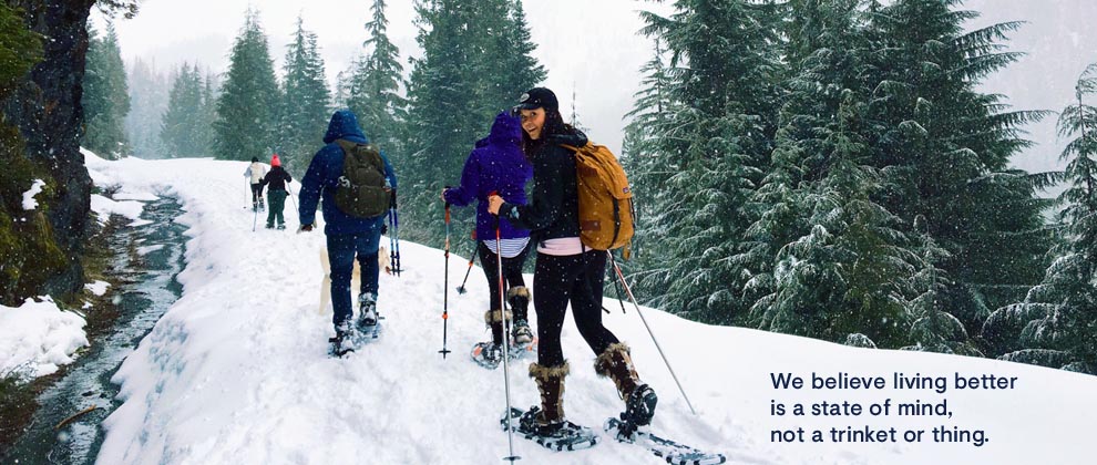 friends outside snowshoeing and smiling