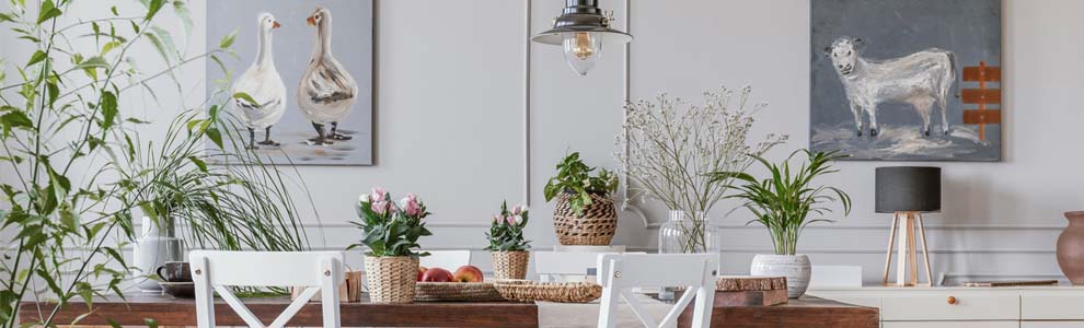 White and wooden furniture in a dining room setting surrounded by light grey walls