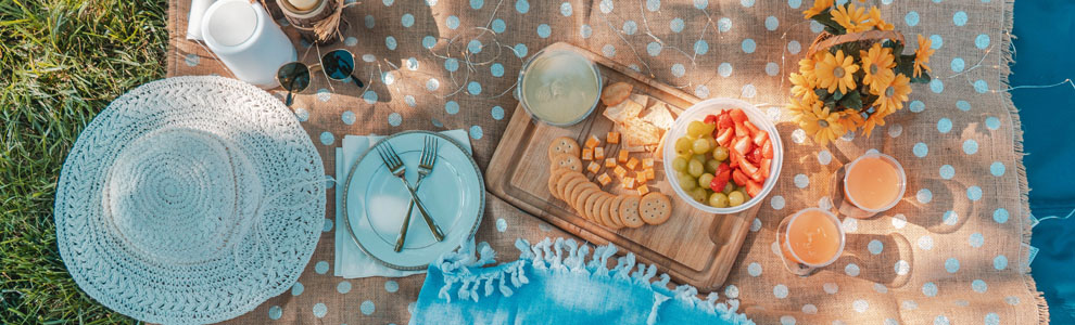Blue and beige blankets with food laid out on it