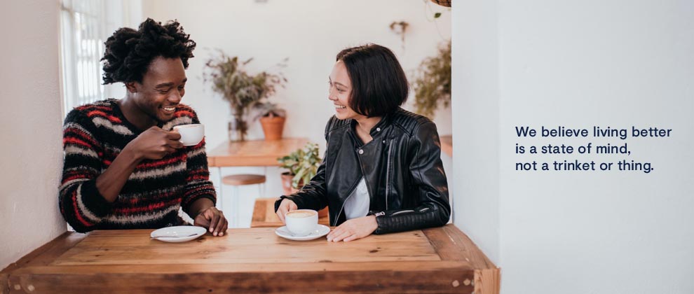 two friends at a coffee shop laughing and talking