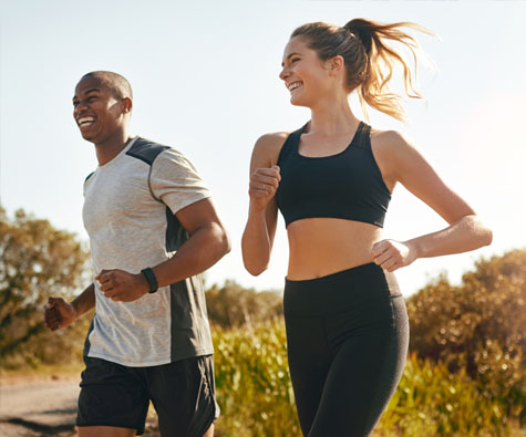 A couple jogging in a park. New condos in Danforth Village by Minto Communities.