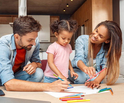 A family drawing together, smiling. New condos in Toronto by Minto Communities.