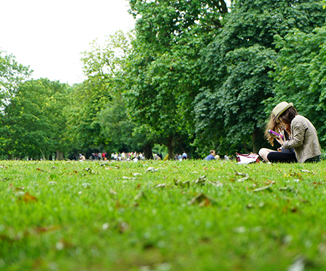 Two people sitting at a park - By Minto Communities.