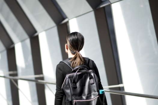 Woman walking with backpack. New condos for sale at Church & Adelaide. The Saint by Minto Communities